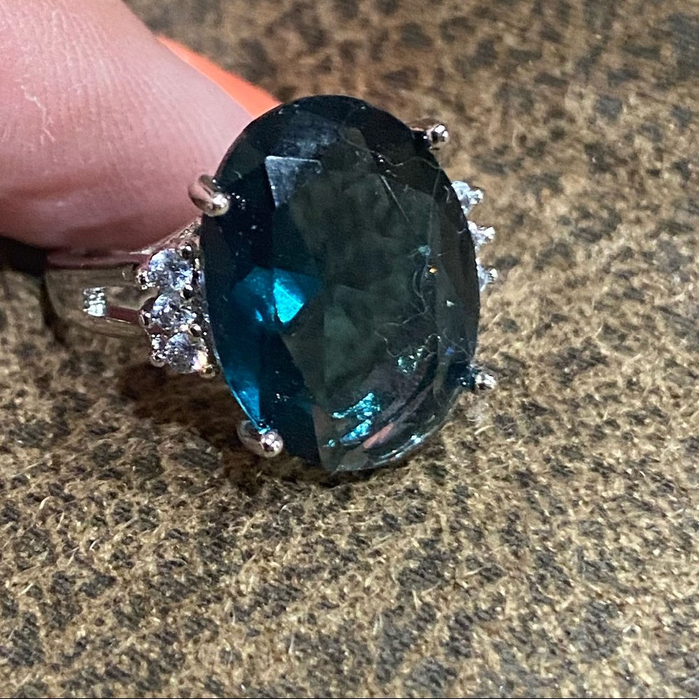 Oval ladies blue stone ring with clear stones.